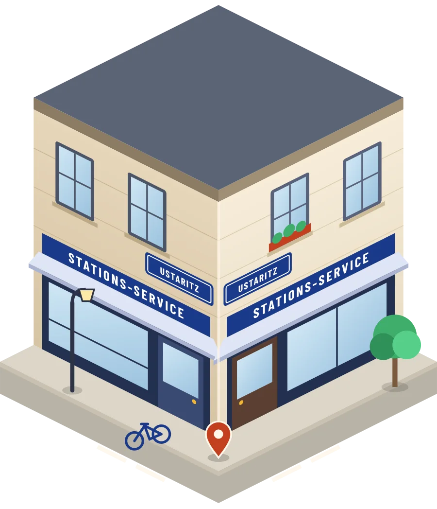 Illustration d'un coin de rue à Ustaritz : deux devantures « Stations-service » à l'angle